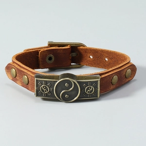 Detailaufnahme eines braunen Lederarmbands mit einem antiken Yin-Yang-Bronze-Emblem