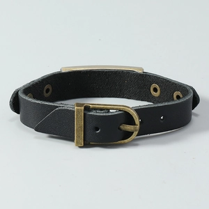 Detail of black leather punk bracelet with bronze metal buckle and engraved plaque plate