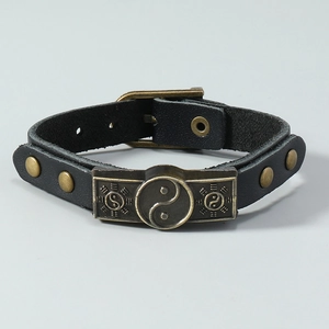 Detailaufnahme des Lederarmbands mit Yin-Yang-Symbol und antikem Gürtelverschluss