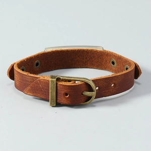 Detail of vintage brown cowhide leather bracelet with antique bronze metal accent plate