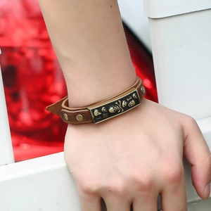 Vintage brown leather skull bracelet with bronze metal plaque shown on a model's wrist