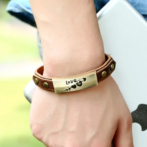 Vintage brown leather punk bracelet featuring heart and arrow engraved brass metal plate