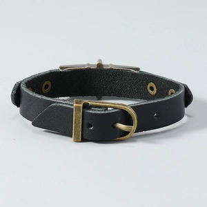 Detail of adjustable black punk leather bracelet with vintage bronze buckle and patina finish