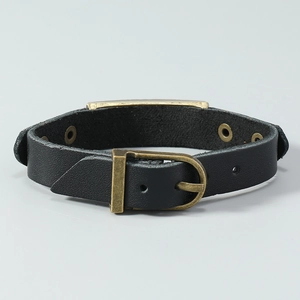 Detail of vintage black leather bracelet with bronze buckle and metal plate centerpiece