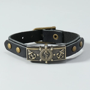 Detail of vintage black leather nautical bracelet with bronze anchor and rudder charms