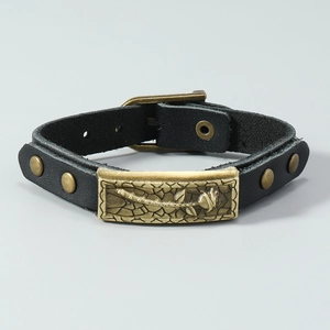 Macro shot of rose flower engraving and rivets on adjustable black leather bracelet