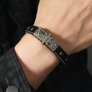 Retro nautical leather bracelet with anchor and rudder charms on male model wrist