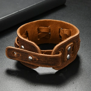 Makro-Detail des braunen Lederarmbands mit geflochtenen Seiten und Nietenverzierung