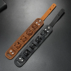 Nahaufnahme von Gothic Punk Lederarmband mit silbernen Nieten und gewebtem Design