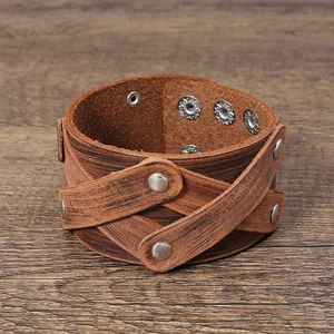 Close-up of vintage brown multilayer leather bracelet with silver studs on wood