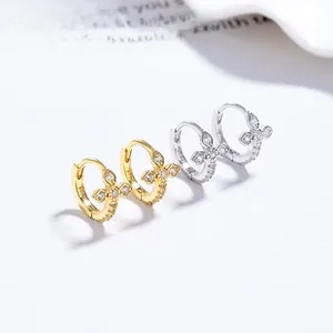 Macro detail of 925 silver cross earrings with zircon pavé in gold and silver finishes