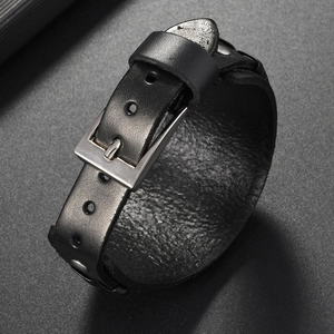 Detail view of adjustable silver metal buckle and rivets on black woven leather bracelet