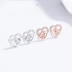 Close-up of S925 sterling silver heart earrings with zircon inlay in silver and rose gold