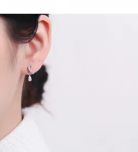 Close-up of 925 sterling silver drop earrings with crossover pavé cubic zirconia