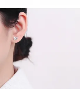 Detail of 925 sterling silver butterfly stud earring worn on ear with polished finish