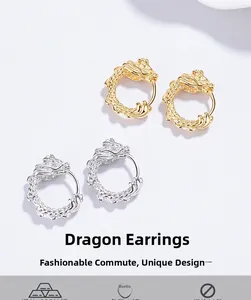 Macro detail of silver and gold dragon hoop earrings with intricate scale texture