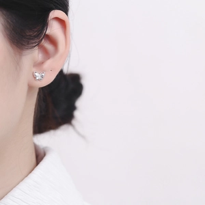 Elegant 925 sterling silver butterfly stud earring worn on ear with a light pink background