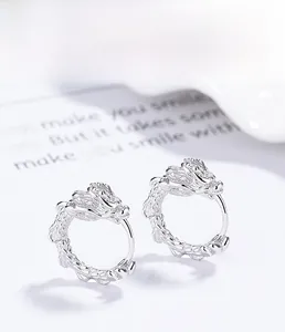 Macro detail of S925 sterling silver dragon earrings with polished electroplated finish