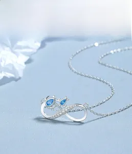 Detail of 925 silver infinity necklace with blue gems and fine diamond accents