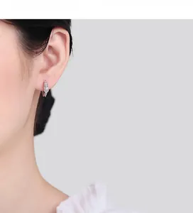 Close-up of 925 sterling silver dragon earrings with sparkling zircon on model ear