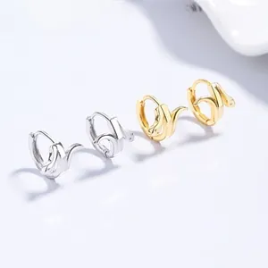 Détail macro de boucles d'oreilles serpent en argent 925 en finitions or et argent