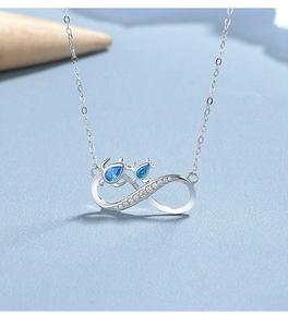 Detail of 925 sterling silver infinity necklace with turtles and blue crystal stones