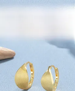 Macro detail of 925 sterling silver leaf earrings with thick 18K gold plating