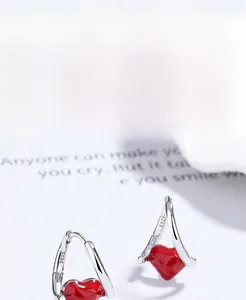 Macro shot of 925 sterling silver heart hoop earrings with glossy red enamel finish