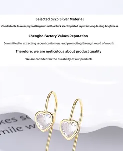 Détail de boucles d'oreilles cœur en argent 925 avec zircon et placage en or fin