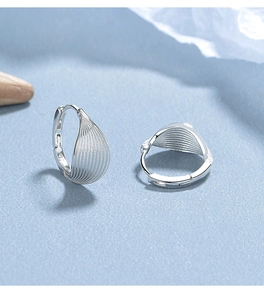 Detailed view of silver leaf hoop earrings featuring fine vertical striped texture