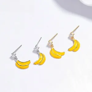 Detailed view of yellow enamel banana stud earrings with shimmering cubic zirconia