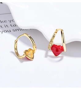 Macro view of S925 hallmark on gold hoop earrings with red enamel heart charms