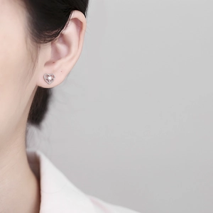 925 silver heart stud earrings with starburst zircon on model in a minimalist style