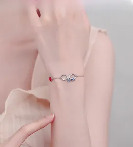 Gros plan du bracelet infini en argent S925 avec pierres bleues et petit cœur rouge