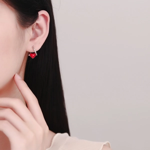 925 sterling silver hoop earrings with a red heart enamel charm on a female model