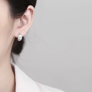 925 Sterling silver leaf-shaped hoop earrings with textured finish on model