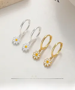 Macro detail of 925 sterling silver daisy hoop earrings with gold and silver enamel finish