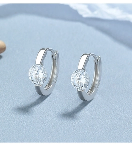 Détail de la boucle d'oreille en argent S925 avec zircon rond brillant sur fond bleu