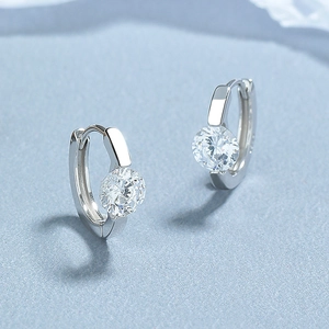 Boucles d'oreilles Huggie en argent 925 avec zircon brillant sur fond bleu clair