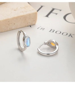 Close-up of 925 silver moonstone hoop earrings with blue iridescent color effect