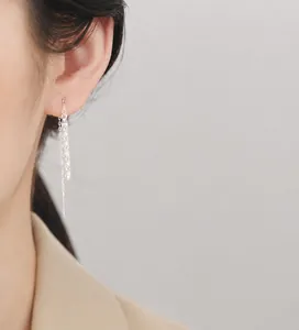 Close-up of 925 sterling silver phoenix tail fringe earrings worn by a model