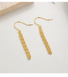 Detail of gold woven cylindrical mesh drop earrings with classic fishhook backing