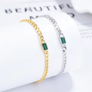 Detail of minimalist 925 silver bracelets with emerald cut green zircon in gold and silver