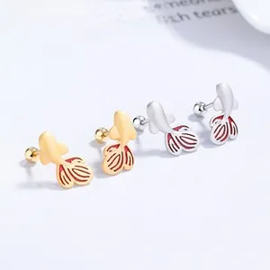 Detailed view of matte gold and silver koi fish stud earrings with red enamel fish tails