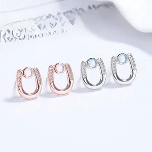 Detailed view of horse-shoe shaped silver studs with moonstone and pavé stone inlay