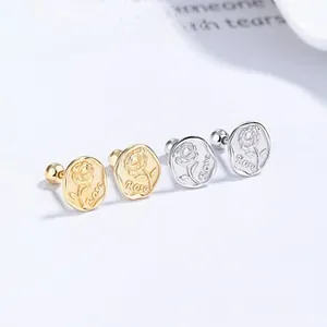 Macro shot of 925 sterling silver rose embossed earrings with screw back in gold and silver