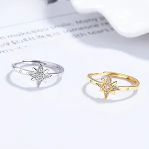 Detail of adjustable silver and gold eight-pointed star rings with zircon inlay