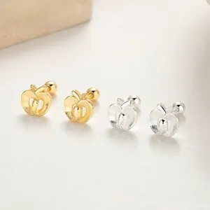 Detail view of hollow apple-shaped stud earrings in polished gold and silver finishes