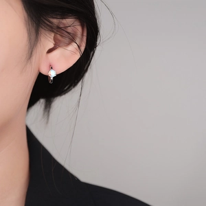 925 silver six-prong olive green zircon hoop earrings worn by a model in a side view