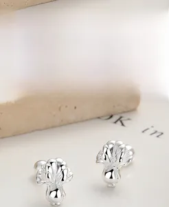 Macro detail of leaf-shaped S925 sterling silver studs with high-polish finish